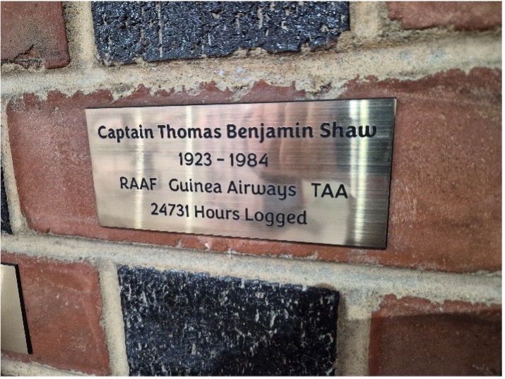 A close view of an engraved commemorative plaque on the wall.